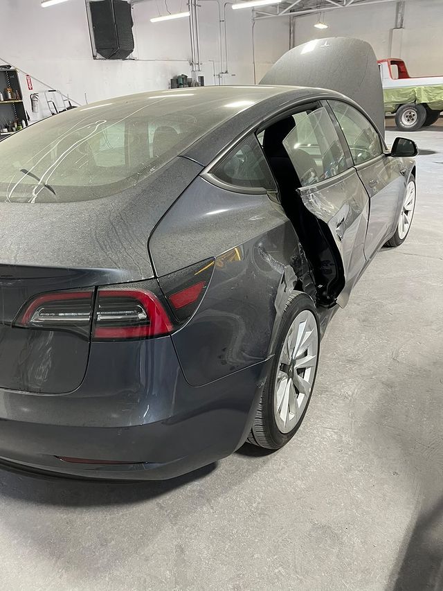 Tesla Model 3 with a damaged rear door in for collision repair